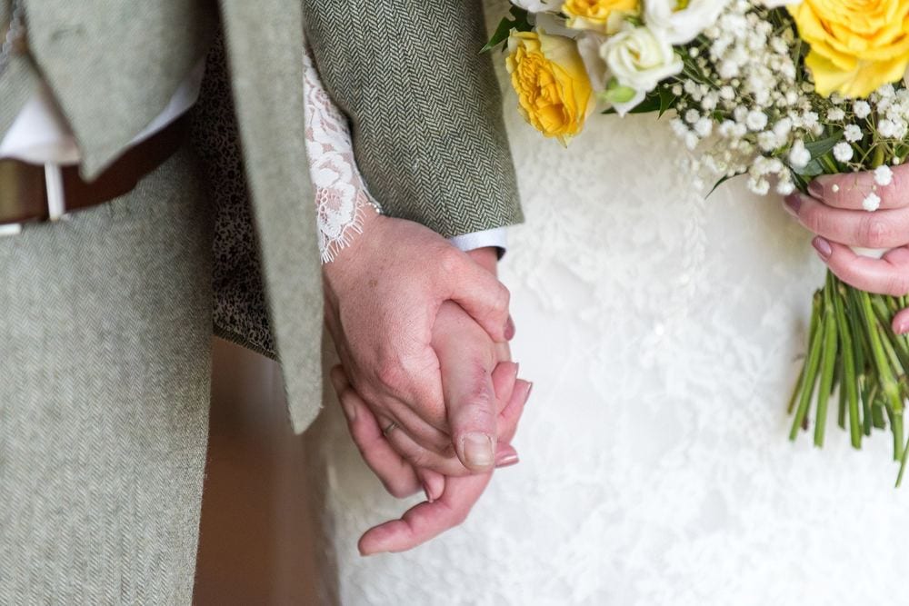 Danielle & Ben hold hands during their wedding ceremony at Woodstock Weddings, York.