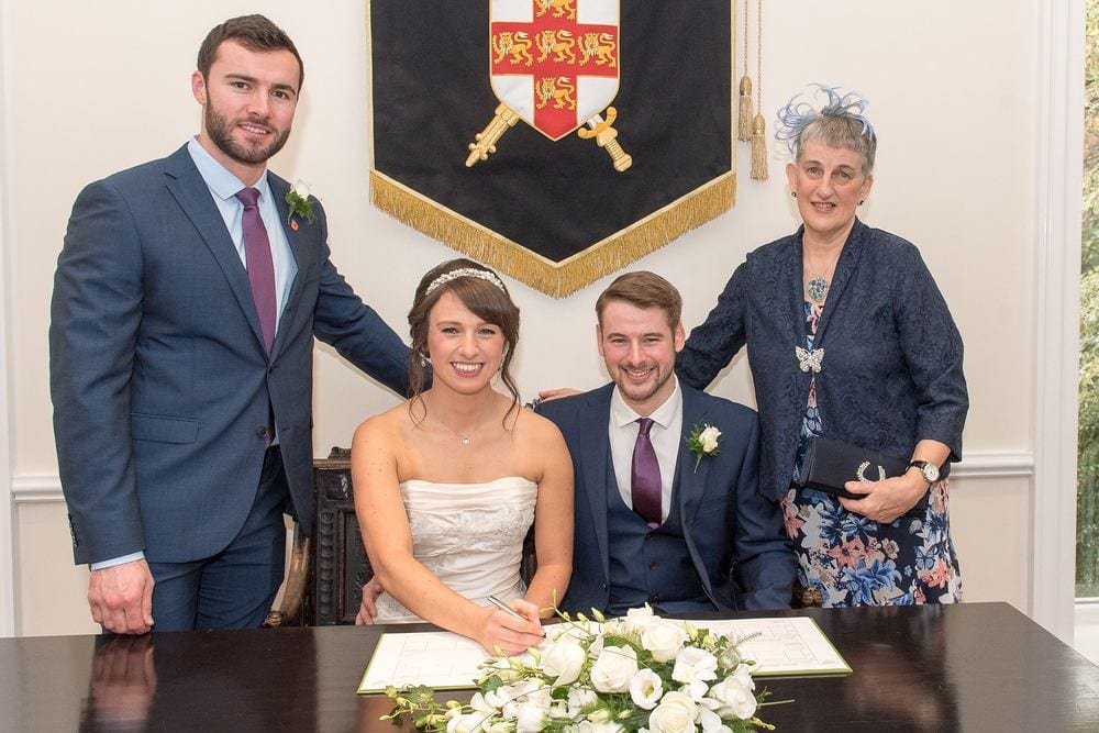 The bride and groom sign the register with their witnesses at York Register Office.