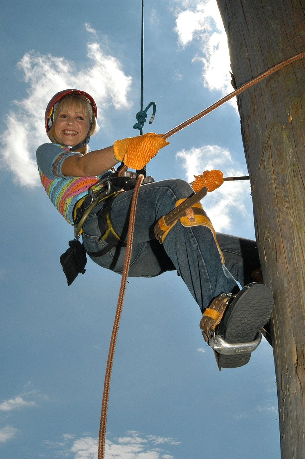 A TV presenter climbing a pole for a feature.