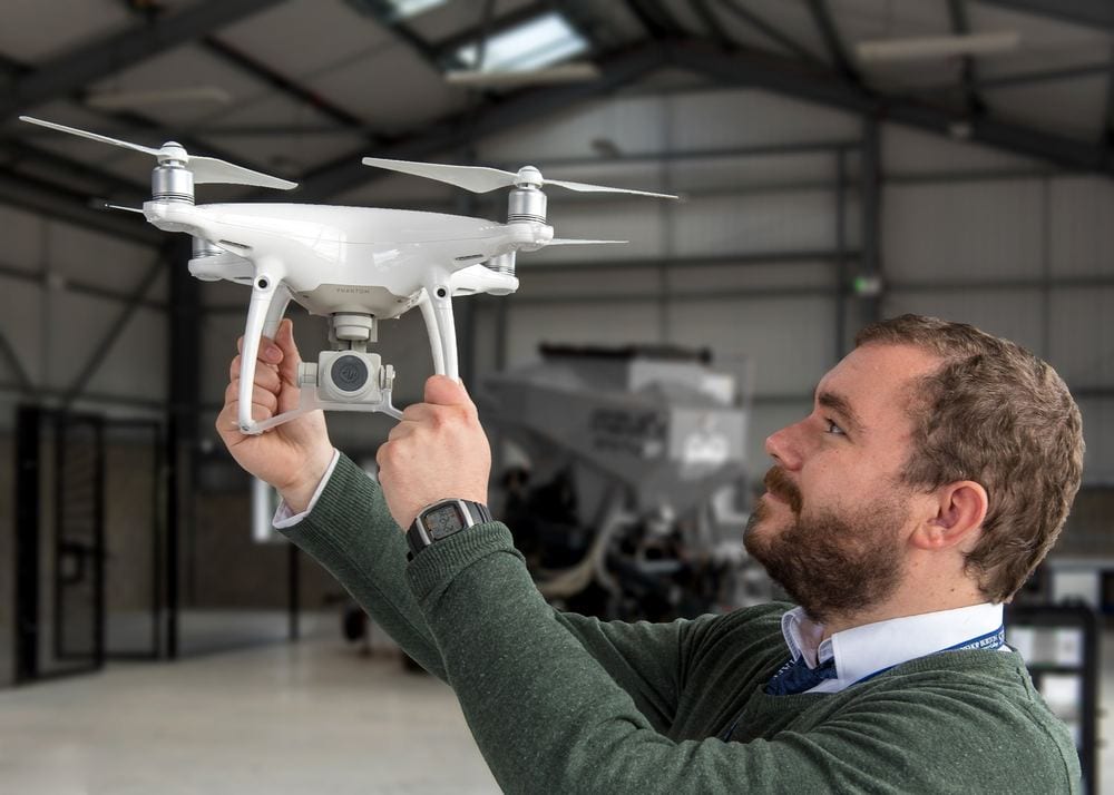 A man holding a drone aloft.