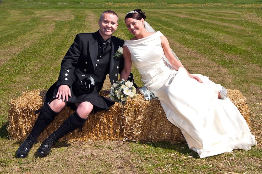 Mark & Emma relax on a straw bale after their wedding at Holy Trinity Church, Elvington.