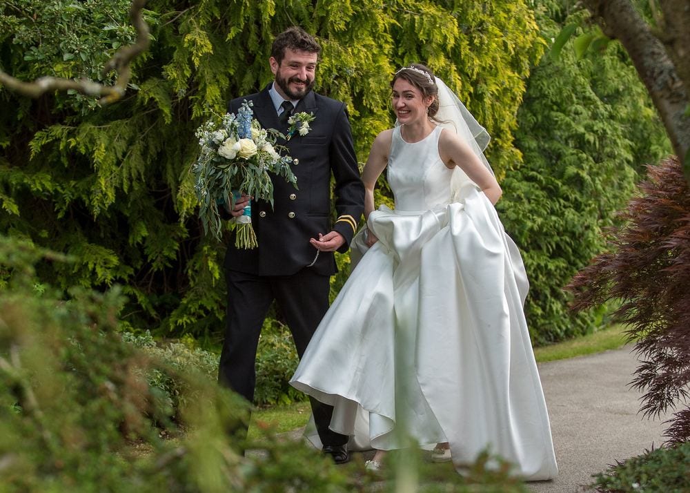 A bride and groom chat as they walk together.