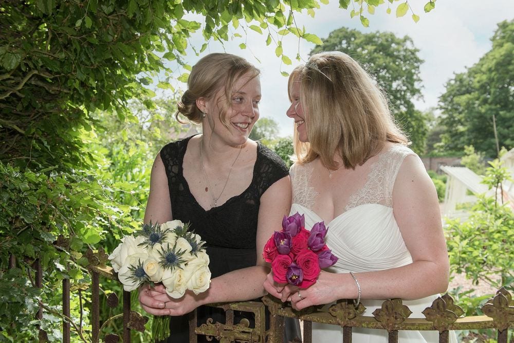 Two brides chat and smile after their wedding at The Little Theatre, Skipwith Hall.