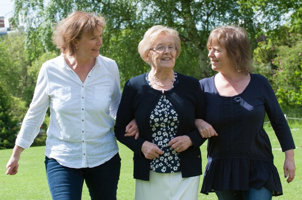 A mum and her two daughters on a countryside walk.