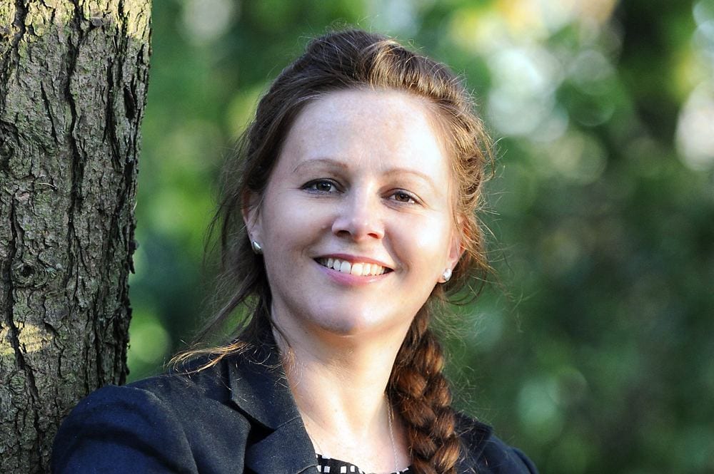 A head-and-shoulders portrait of a confident woman.